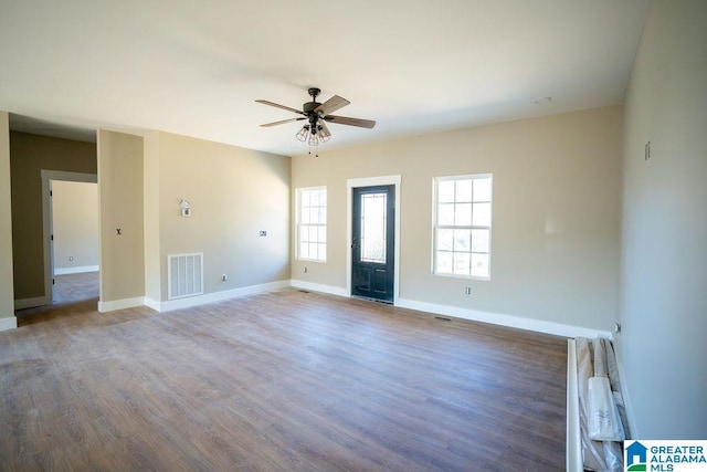 interior space with visible vents, baseboards, ceiling fan, and wood finished floors