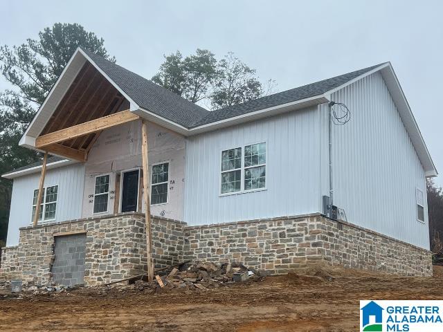 view of property exterior featuring stone siding and an attached garage