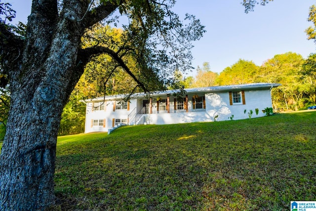 rear view of house featuring a yard