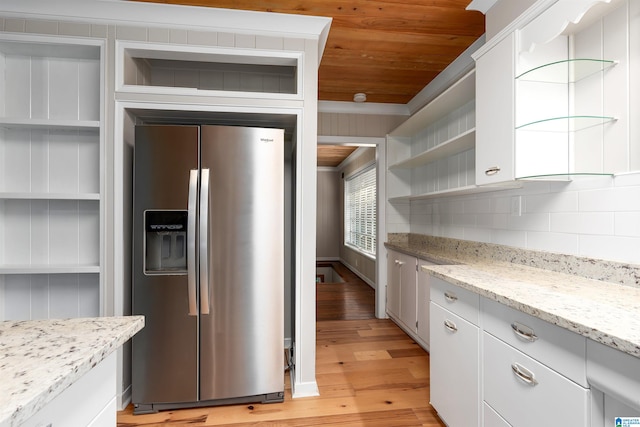 kitchen with light stone countertops, light wood-type flooring, white cabinetry, decorative backsplash, and stainless steel fridge with ice dispenser