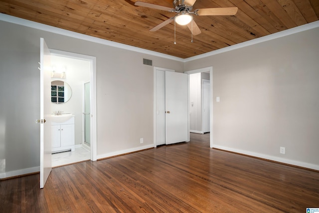 unfurnished bedroom featuring wood ceiling, dark wood-type flooring, crown molding, ensuite bathroom, and ceiling fan