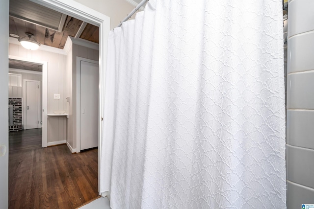 interior space featuring hardwood / wood-style floors, a shower with shower curtain, and crown molding