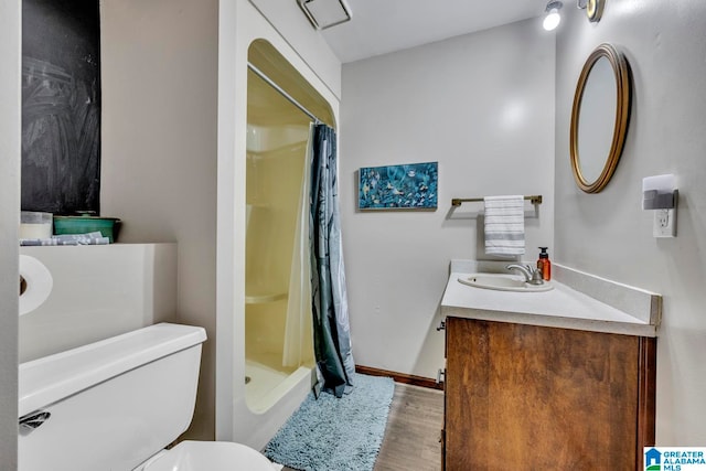 bathroom featuring vanity, wood-type flooring, toilet, and walk in shower