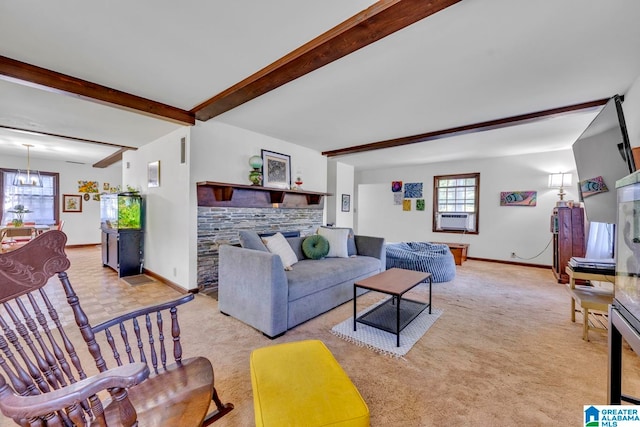 living room with beam ceiling, a chandelier, a stone fireplace, and light colored carpet