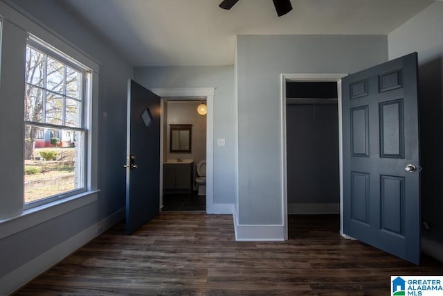 unfurnished bedroom featuring a closet, ceiling fan, multiple windows, and dark hardwood / wood-style flooring