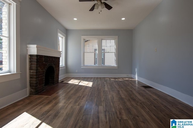 unfurnished living room featuring ceiling fan, dark hardwood / wood-style flooring, and a fireplace