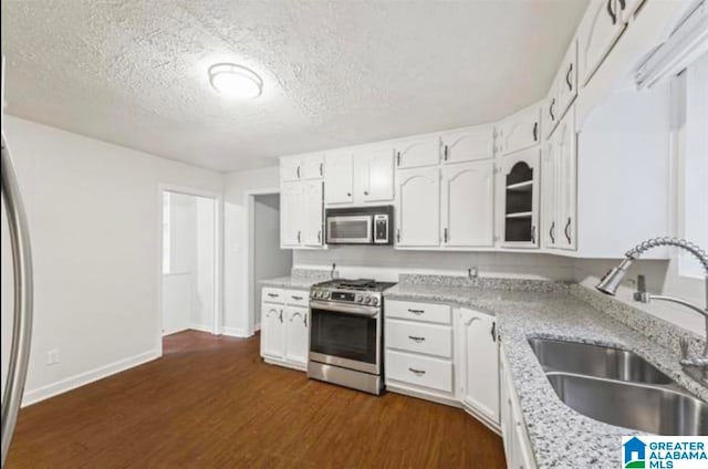 kitchen featuring dark wood-type flooring, white cabinetry, sink, and appliances with stainless steel finishes