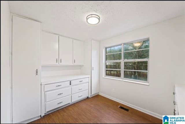 unfurnished bedroom with a textured ceiling and hardwood / wood-style flooring