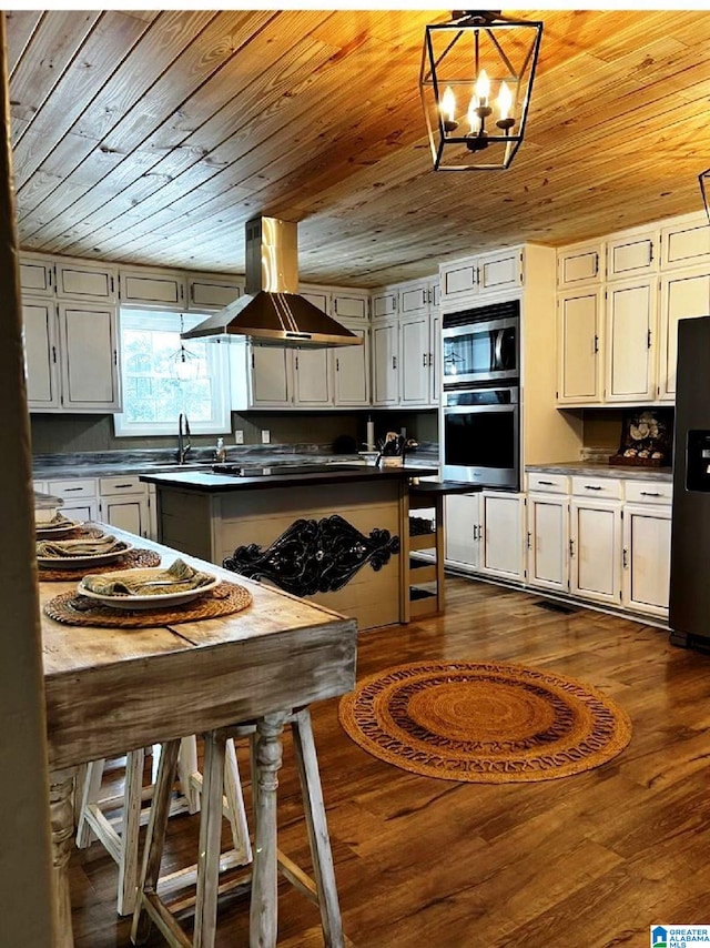765 2nd Ave, Ashland, AL 36251 - kitchen with island exhaust hood, appliances with stainless steel finishes, wooden ceiling, dark countertops, and dark wood-style flooring