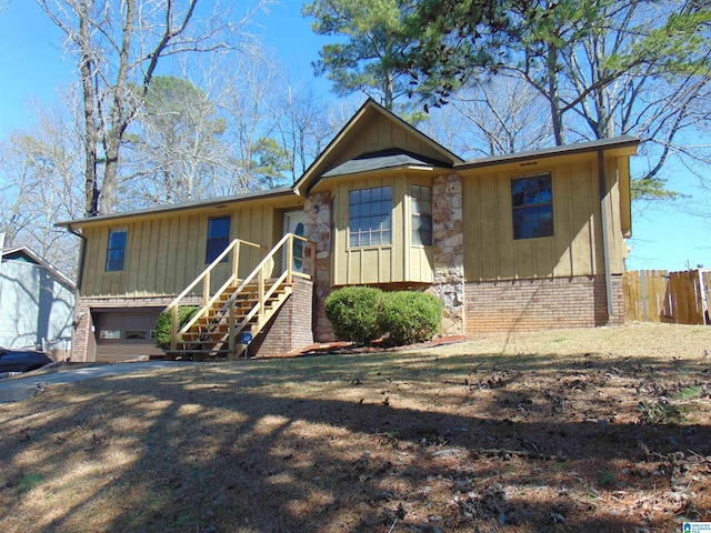 view of front of property featuring stairway, an attached garage, fence, and brick siding