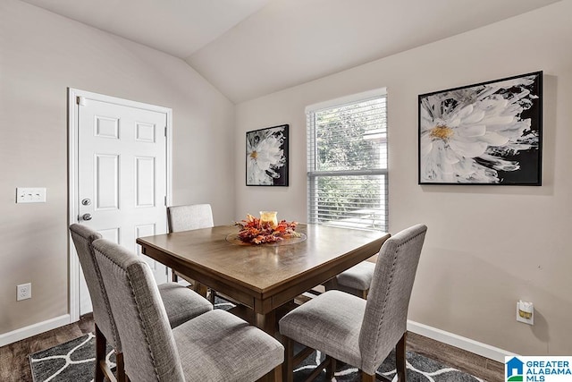 dining room with vaulted ceiling and dark hardwood / wood-style floors