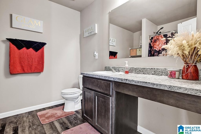 bathroom featuring vanity, toilet, and hardwood / wood-style flooring