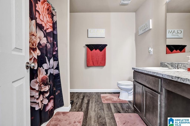 bathroom featuring toilet, vanity, and wood-type flooring