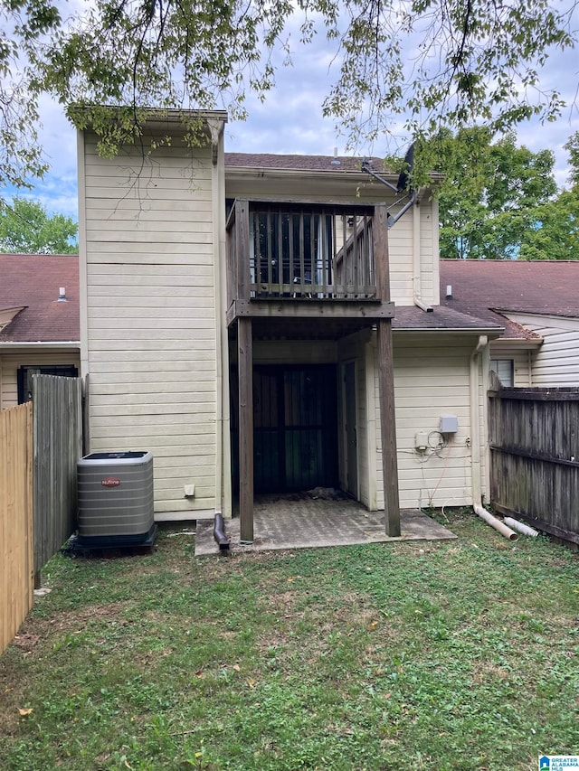 rear view of house with a patio, a lawn, and central air condition unit