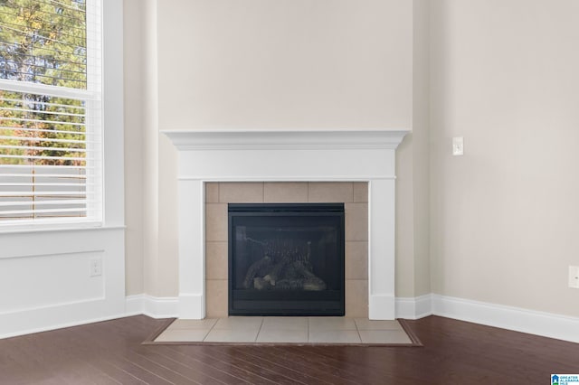 interior details featuring hardwood / wood-style flooring and a tile fireplace