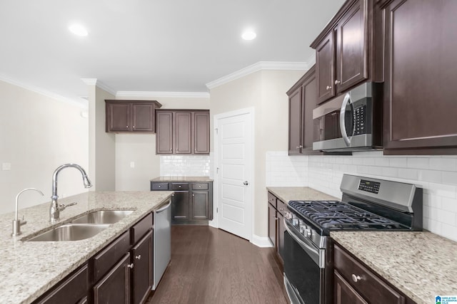 kitchen featuring appliances with stainless steel finishes, light stone countertops, dark hardwood / wood-style floors, ornamental molding, and sink