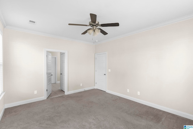 carpeted spare room with ceiling fan and ornamental molding