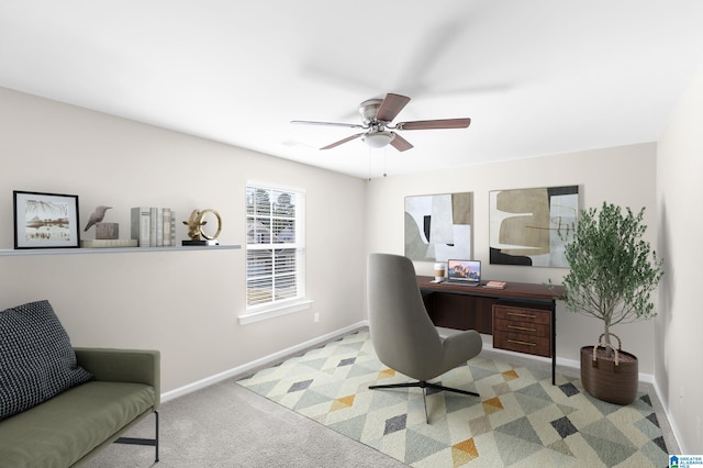 carpeted home office featuring ceiling fan