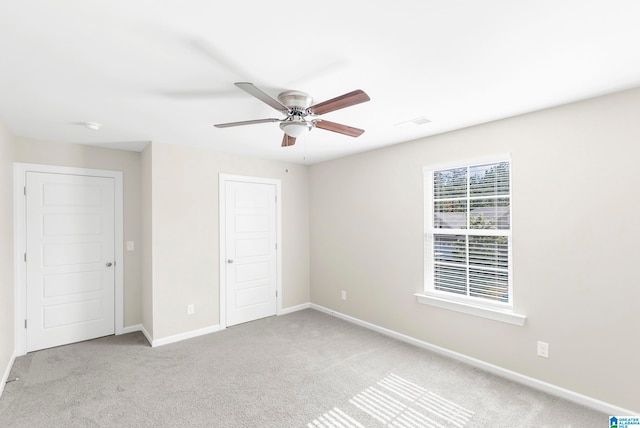 unfurnished bedroom with light colored carpet and ceiling fan