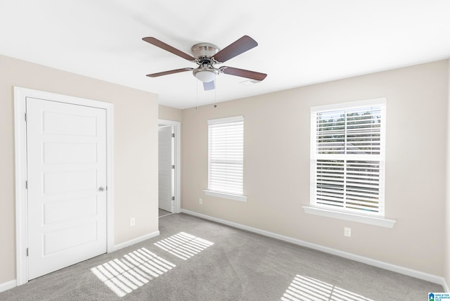 unfurnished bedroom with ceiling fan and light colored carpet