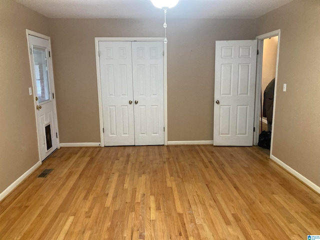 unfurnished bedroom featuring a closet and light hardwood / wood-style floors