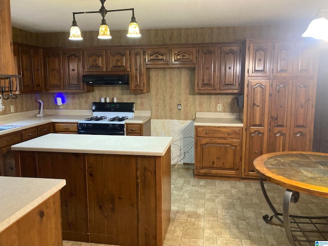 kitchen featuring a kitchen island, white range with gas stovetop, and hanging light fixtures