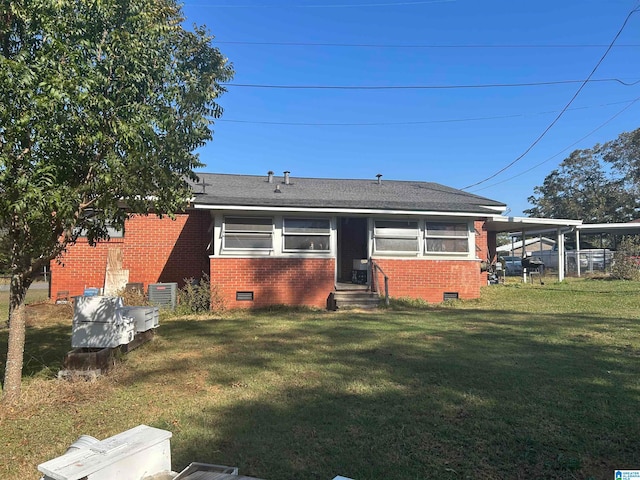 rear view of house with a carport and a lawn