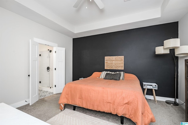 carpeted bedroom with a raised ceiling and ceiling fan