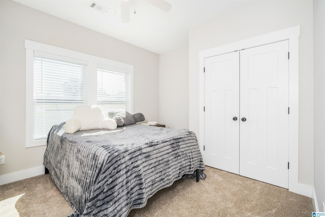 bedroom featuring a closet, ceiling fan, and light carpet