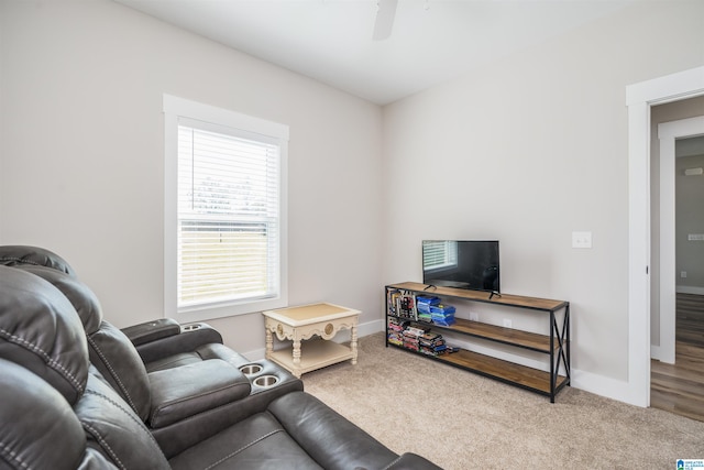 carpeted living room with ceiling fan