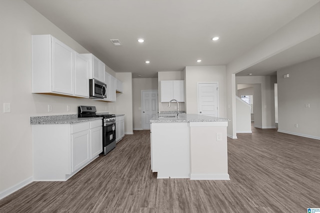 kitchen featuring white cabinetry, an island with sink, hardwood / wood-style flooring, and appliances with stainless steel finishes