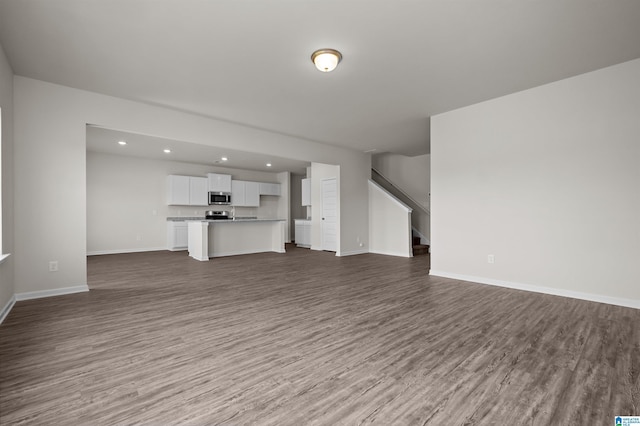 unfurnished living room with dark wood-type flooring