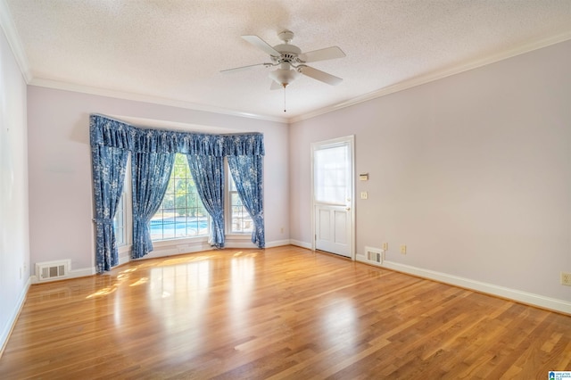 spare room with light hardwood / wood-style flooring, ornamental molding, a textured ceiling, and ceiling fan