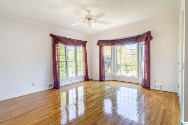 unfurnished room featuring light hardwood / wood-style floors, ornamental molding, a textured ceiling, and ceiling fan