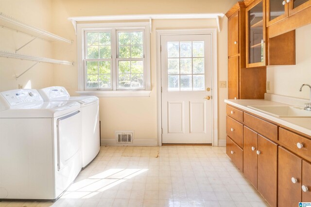 washroom featuring cabinets, sink, and washer and clothes dryer