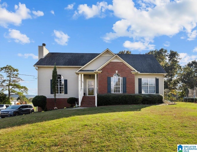 view of front of house with a front yard and a trampoline