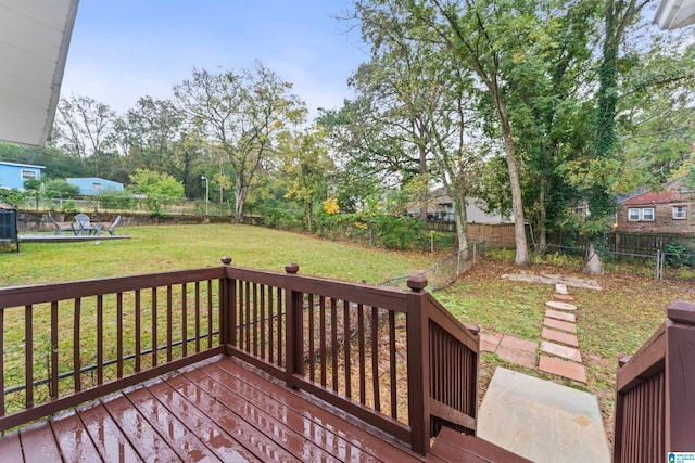 wooden deck featuring a lawn