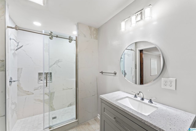 bathroom with hardwood / wood-style floors, walk in shower, and vanity