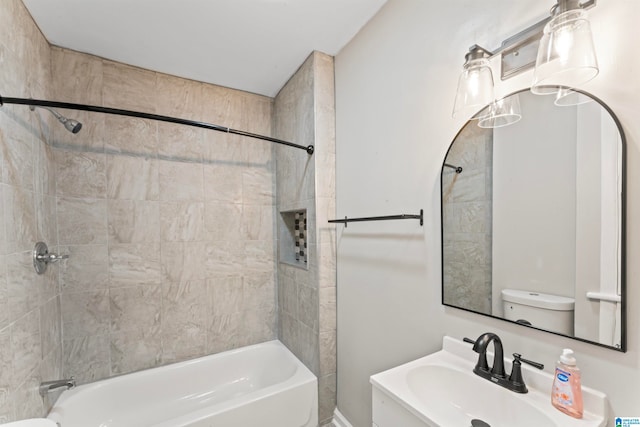 full bathroom featuring toilet, tiled shower / bath, and sink