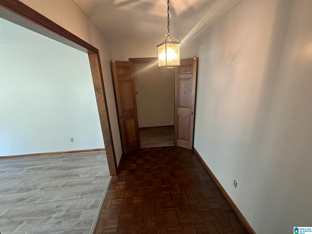 hall with dark parquet flooring and a textured ceiling