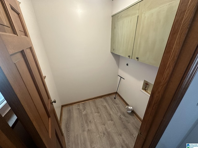 clothes washing area featuring light hardwood / wood-style flooring, cabinets, and washer hookup