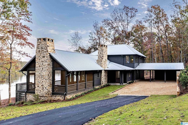 view of front of house with a carport, a front yard, and a water view