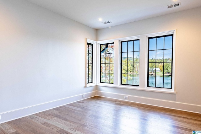 empty room featuring hardwood / wood-style floors and a water view