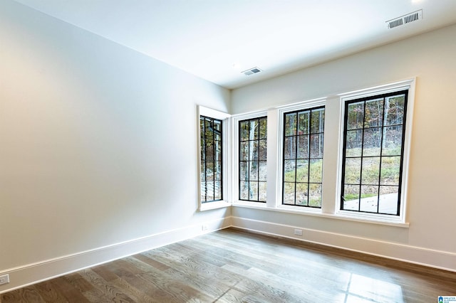 unfurnished room with hardwood / wood-style flooring