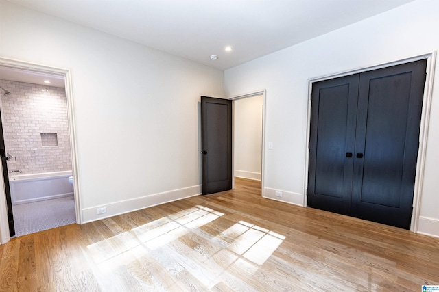 unfurnished bedroom featuring light hardwood / wood-style floors and a closet