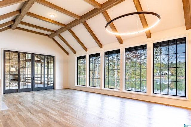 unfurnished sunroom featuring lofted ceiling with beams and french doors