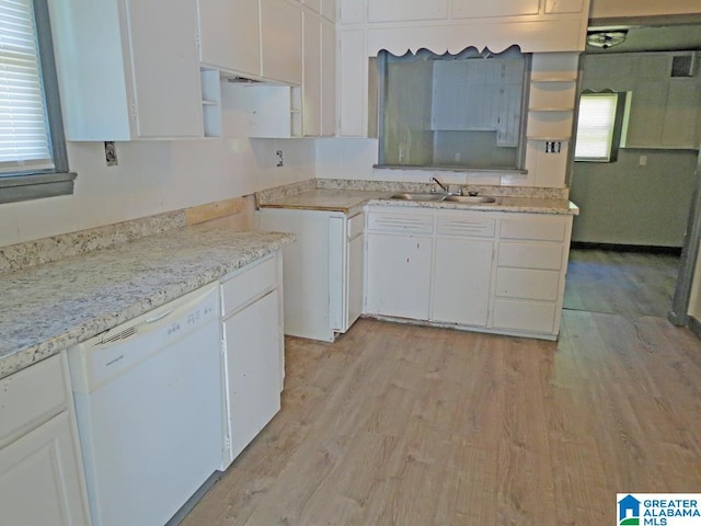 kitchen featuring white dishwasher, sink, light hardwood / wood-style floors, light stone counters, and white cabinetry