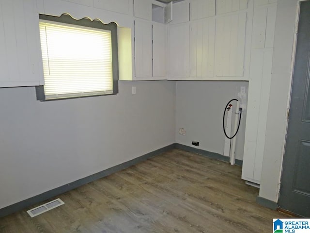 washroom with cabinets, washer hookup, and dark hardwood / wood-style floors