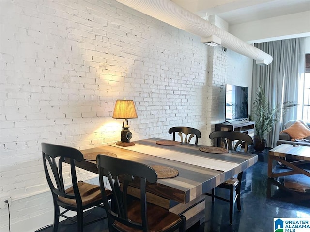2327 Morris Ave Unit 2C, Birmingham, AL 35203 - dining area featuring brick wall and concrete flooring