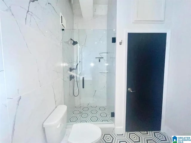 bathroom featuring a tile shower and toilet